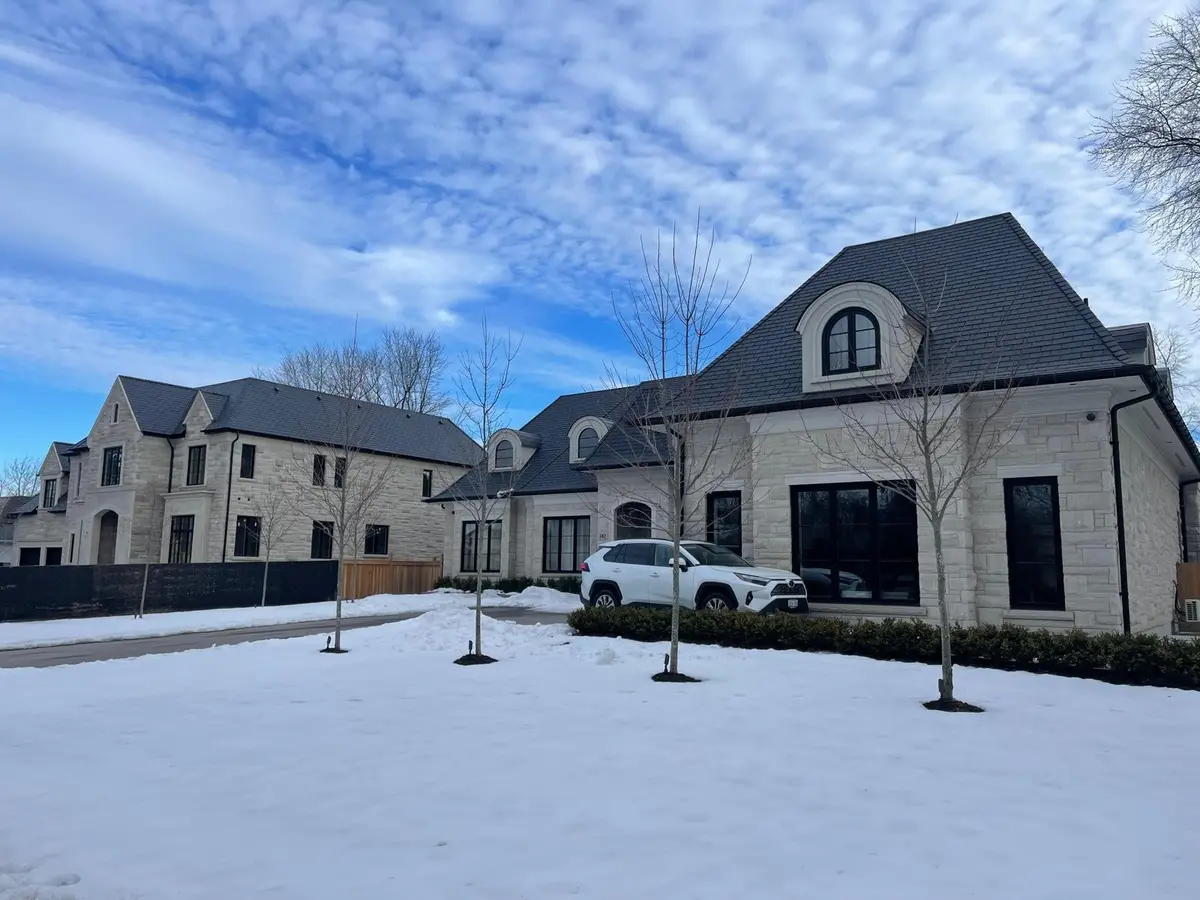 Stone estate home with a new dark roof in winter: storm damage & insurance claims by Eagle Roofing