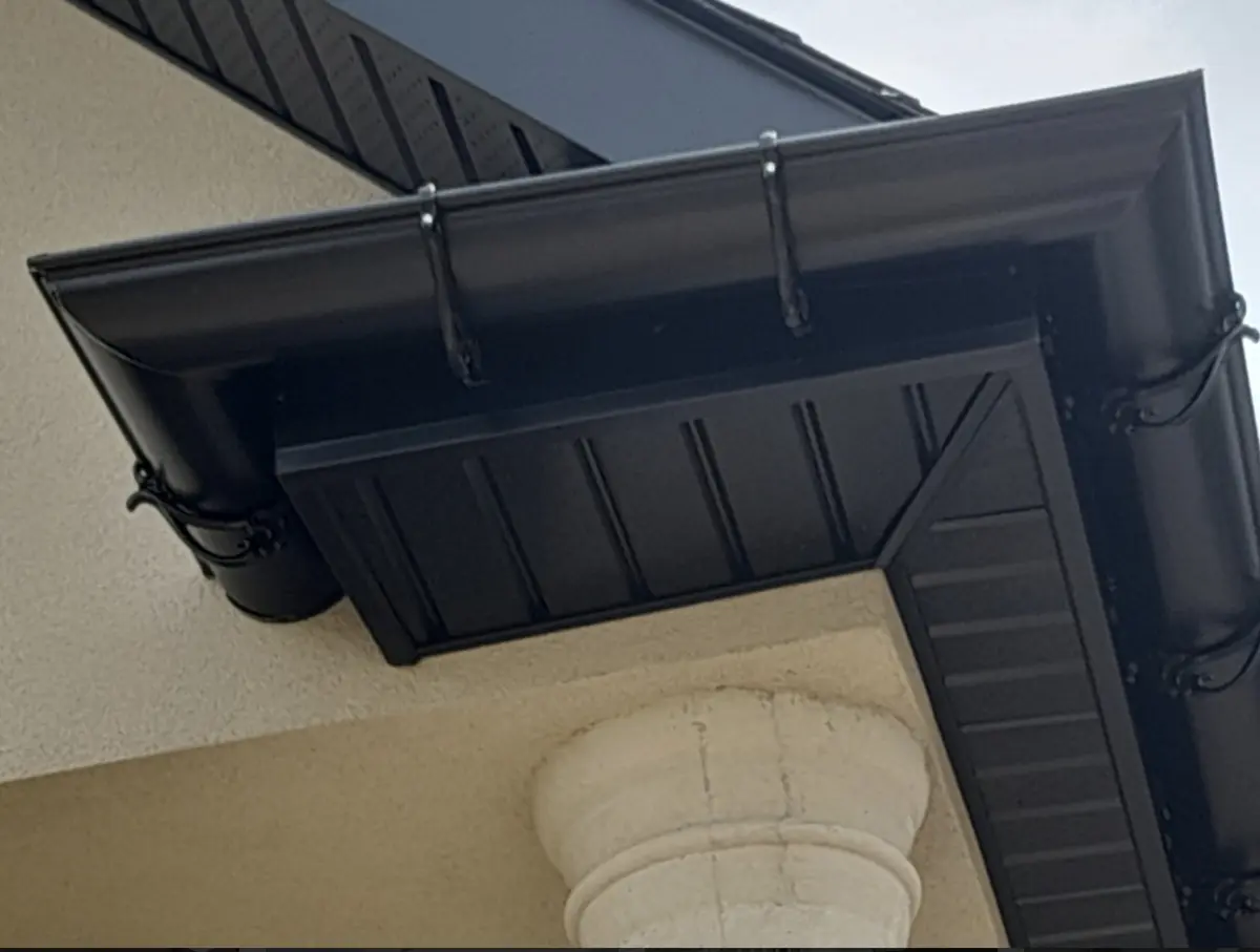 New black soffit, fascia and eavestrough at a roof corner over a column: eavestrough, soffit & fascia by Eagle Roofing